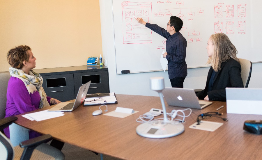 Minitab InfoCenter feature image: Two people in a conference room listening to a presentation.